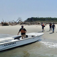 A person stands on a boat that's beached