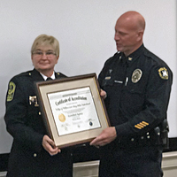 Chief Cheesebro receives a framed certificate from Chief Rinehimer