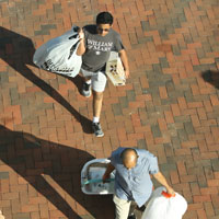Aerial view of two people moving items into dorms