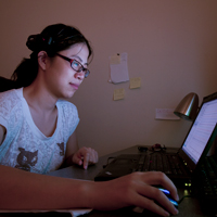 A student writes computer code on a desktop
