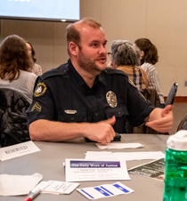A police officer who created autism stickers talks with others in a small group. (Photo by Nicholas Meyer '22)