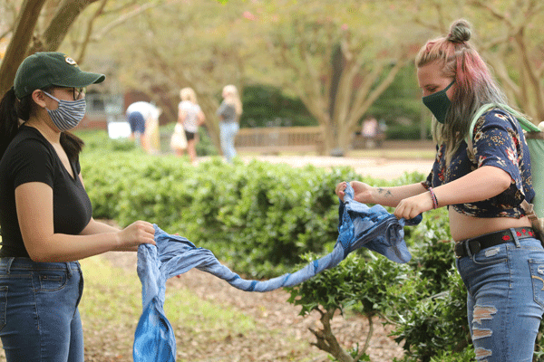 Students work on the cyanotypes project by wringing and twisting liquid out of cloth after processing. (Photo by Stephen Salpukas)