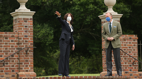 Katherine Rowe and John Dickerson wear masks and stand at the top of steps to the Sunken Garden