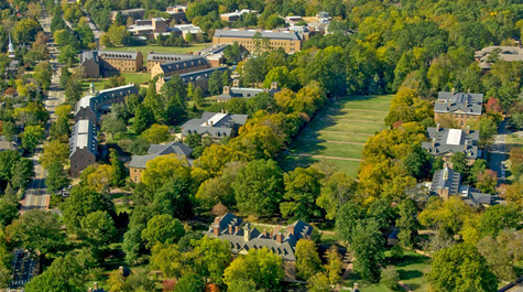 An aerial view of campus shows brick buildings, green trees and open areas