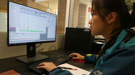 Chemistry student Hongmin Yu analyzes data in the lab