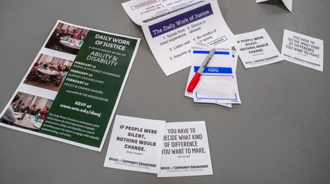 A poster, blank name tags and other paper materials on a table