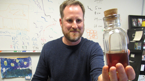 William & Mary geologist Jim Kaste examines a jar of honey