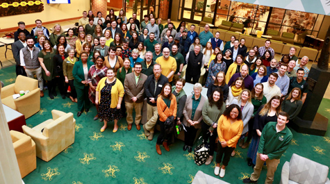 A large group of people stand in the center of the Sadler Center and look up toward the camera