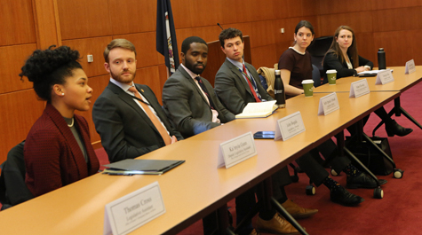 A group of panelists sit at tables