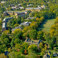 An aerial view of campus shows brick buildings, green trees and open areas