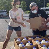 Anna Laws collects gallons of milk for distribution 