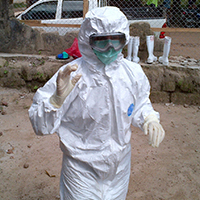 Megan Casey stands dressed head to toe in personal protective equipment