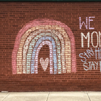 Encouraging words written on brick wall