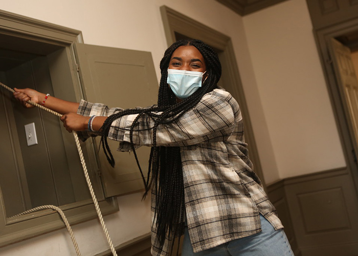 A William & Mary student excitedly rings the Wren bell on the last day of classes in the fall of 2020. (Photo by Stephen Salpukas)