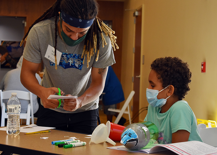 Miguel Jones, a sophomore at W&amp;M, works with one of the EAGER campers to build a rocket made from a soda bottle.  