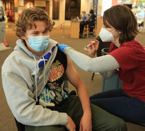 Cheryl Worthington (right) gives Conor McCambridge ‘23 a vaccination shot. (Photo by Stephen Salpukas)