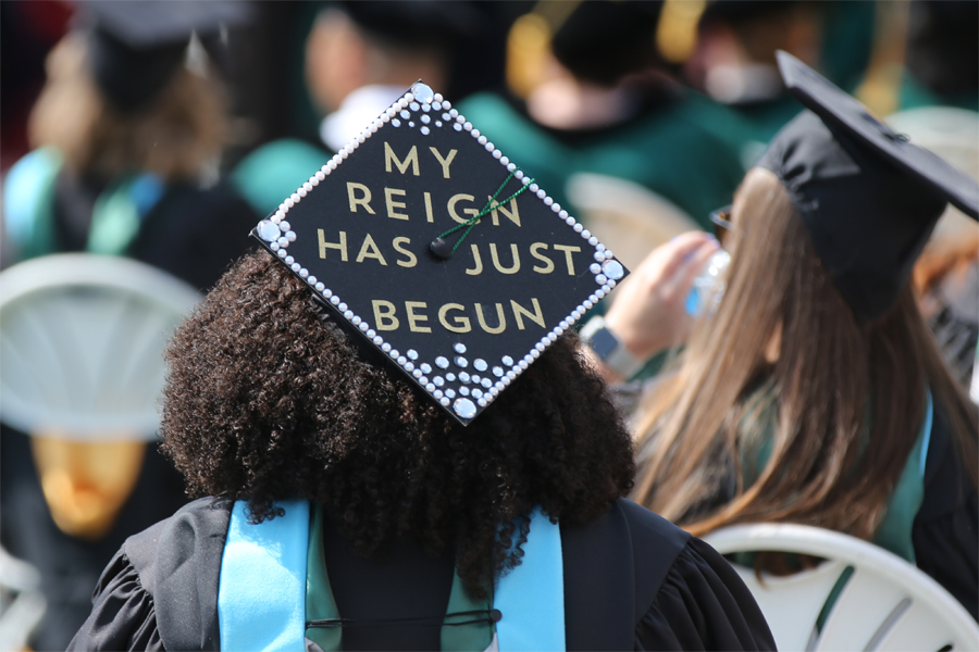 A mortarboard decorated with pearl-like beads and the words, my reign has just begun.