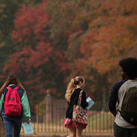 Students walking on campus with fall foliage 