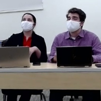 masked students work on laptops