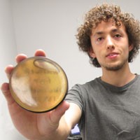A person holds a glass disc with honey