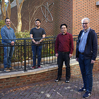Researchers stand outside brick building