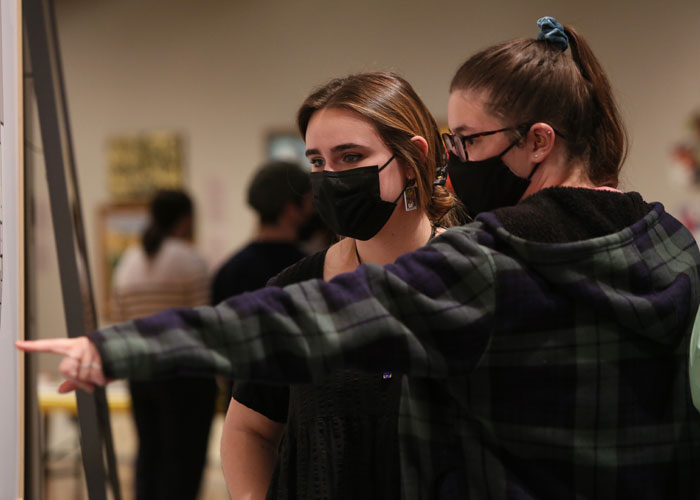 Students work together to research, analyze and choose which information to include in the final exhibition as part of the Curatorial Project course. (Photo by Stephen Salpukas)