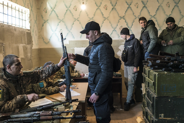 Military volunteers in Fastiv, Ukraine, receive weapons on Feb. 25 after the Ukrainian government announced they would arm civilians to resist the Russian invasion. (Photo by Brendan Hoffman)