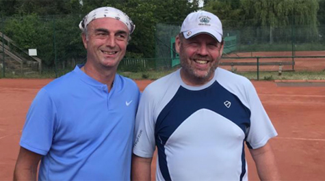 Two people stand on a tennis court