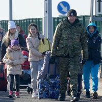 A crowded lineup of Ukrainian people carrying luggage, wearing winter coats and hats