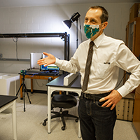 A professor stands inside a lab