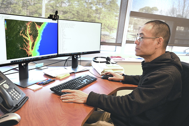 Joseph Zhang, research professor in the Center for Coastal Resources Management at VIMS, examines a simulation of water motion on a computer