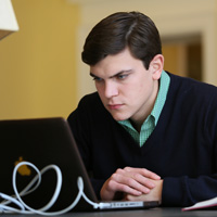 Student studying in front of a laptop computer.