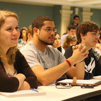 Closeup of several students listening to a class lecture.