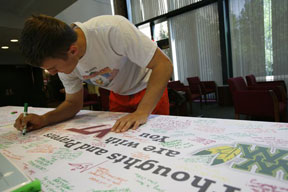 Sophomore Michael Campbell signs a prayer letter. By Stephen Salpukas.