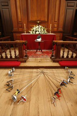 Members of the fencing club placed their weapons on the floor in tribute to Ben Gutenberg. By Stephen Salpukas.