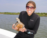 Sarah Sumoski with a diamondback terrapin during field work for her study of eelgrass dispersal. Photo by Diane Tulipani.