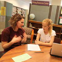 Aleina Kreider (L) works with a student.