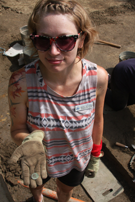 Crystal Castleberry, an intern on the dig, displays an 18th century coin bearing the head of King George III. The coin was one of the thousands of artifacts recovered during the two summers of excavation at Brown Hall. Photo by Joseph McClain.