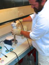 Researcher Kory Angstadt uses a stir plate to prepare microbeads in the laboratory at VIMS.