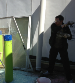 Alex Thomson '14, a member of the Ruritan club, prepares a damaged storm door for recycling.