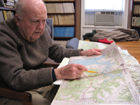 Mitchell Byrd looks over a set of topographic maps he uses to mark the location of eagles nest. Byrd, 85, is serving his 38th year of census flights to track the population of Virginia’s bald eagles. Photo by Joseph McClain