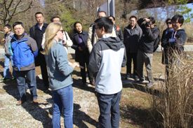 Outreach Specialist Kattie McMillan and graduate student Zhengui Wang (foreground) show part of the group through the VIMS Teaching Marsh. Wang and other Chinese students at VIMS served as translators for the visitors.