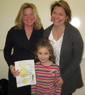 Lyra Swaddle, daughter of William & Mary geologist Rowan Lockwood (right) presented Ellen Stofan with a signed, original drawing of the solar system following Stofan’s talk to geologists and geology students. “I’m going to put this on the wall of my office,” Stofan told Lyra. Photo by Joseph McClain.