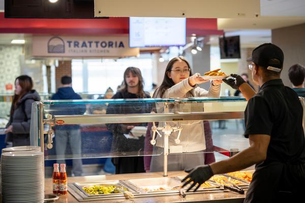 Dining staff member serving student in Sadler dining hall