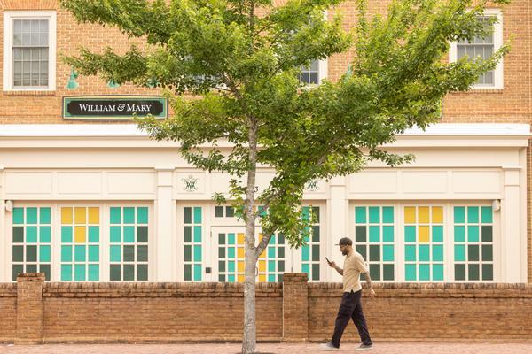 Person walking in front of Tribe Square storefront