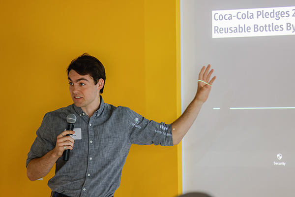 A student presenting with a microphone in front of a projection screen