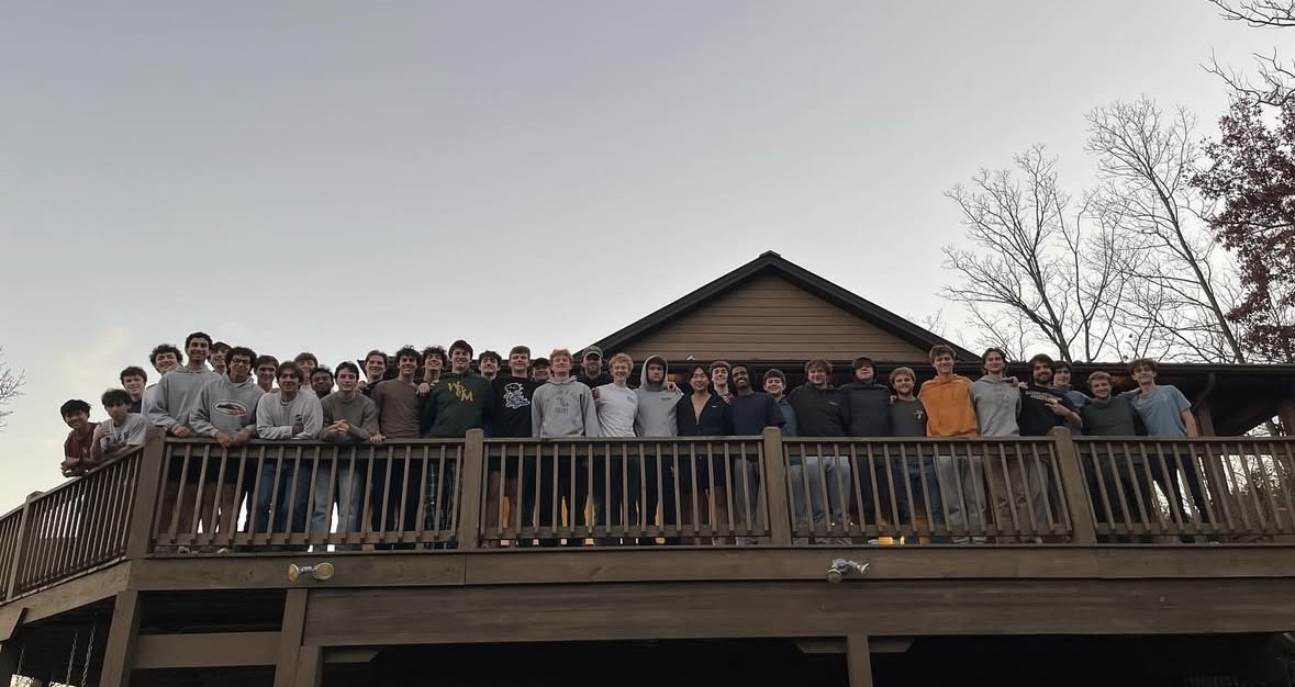 Delta Chi brothers pose together on a second floor outdoor deck.