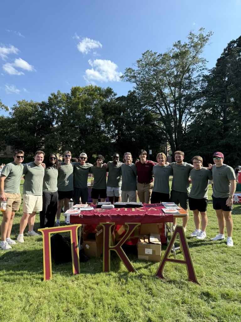 Members of Pi Kappa Alpha behind an event table.