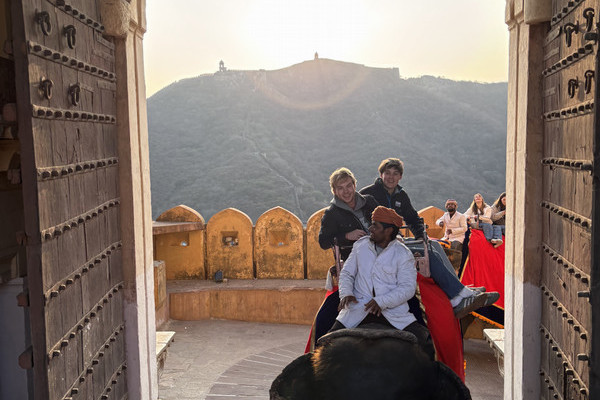A group of people ride an elephant in India.
