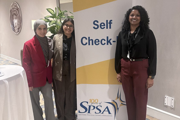 Students stand by an SPSA sign.